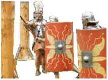 Due legionari si allenano con il gladio contro dei pali di legno sotto la supervisione di un centurione